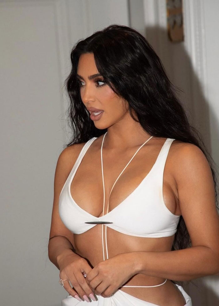 Kim Kardashian wearing white revealing top, related to wig for private parts and intimate hair underwear trend.