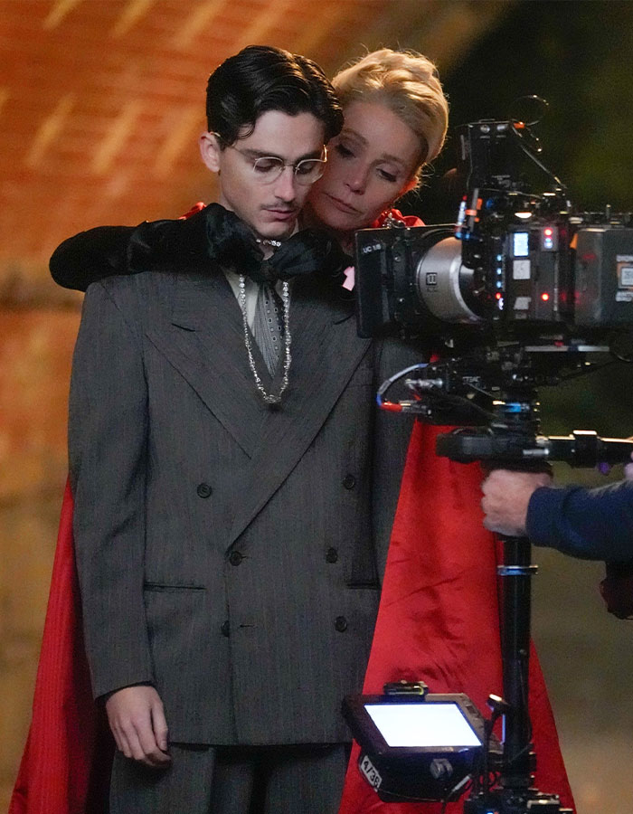 Gwyneth Paltrow embracing Timoth&eacute;e Chalamet on set during filming, with camera crew capturing the scene.