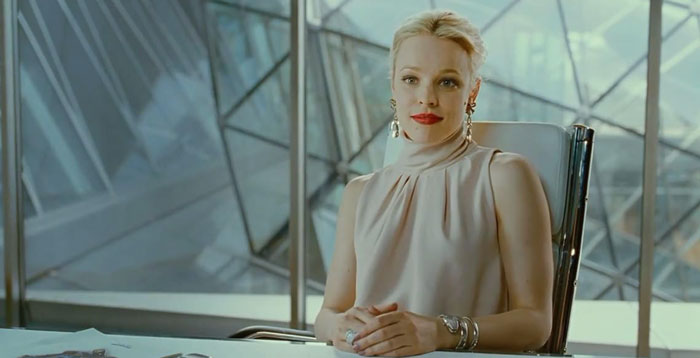 Rachel McAdams with a natural look in a light sleeveless top sitting confidently in a modern office setting. Rachel McAdams with a natural look in a light sleeveless top sitting confidently in a modern office setting.
