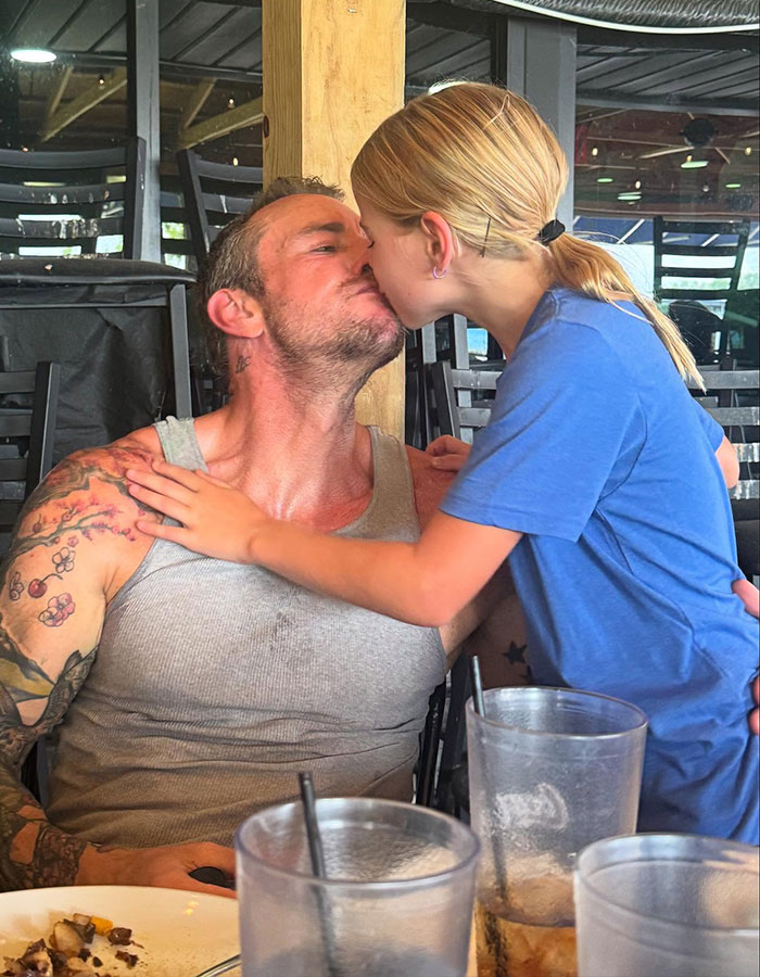 Kristen Bell and Dax Shepard sharing a close moment at a casual dining setting with drinks and plates visible. Kristen Bell and Dax Shepard sharing a close moment at a casual dining setting with drinks and plates visible.