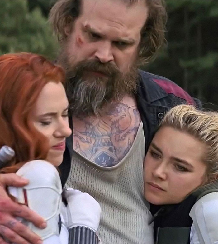 David Harbour looking serious while interacting with two women half his age in a viral controversial moment.