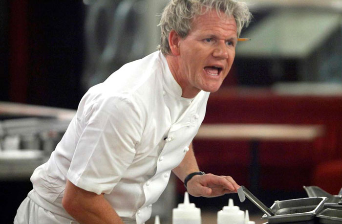 Renowned chef in white uniform passionately speaking in a kitchen, symbolizing strength and resilience after narcissistic mothers.
