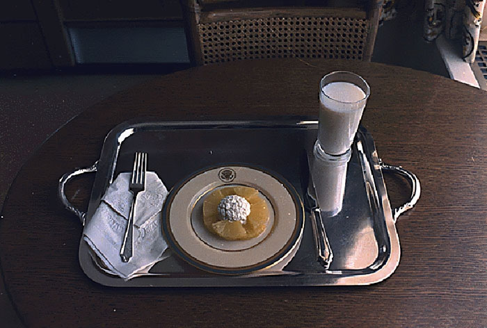 Silver tray with a small dessert and a glass of milk, illustrating an unexpected historical story about rabbits attacking Napoleon.