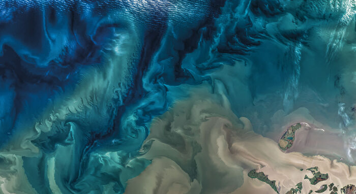 Abstract satellite image showing swirling ocean patterns and landforms, capturing the beauty and mystery of space and astronomy.