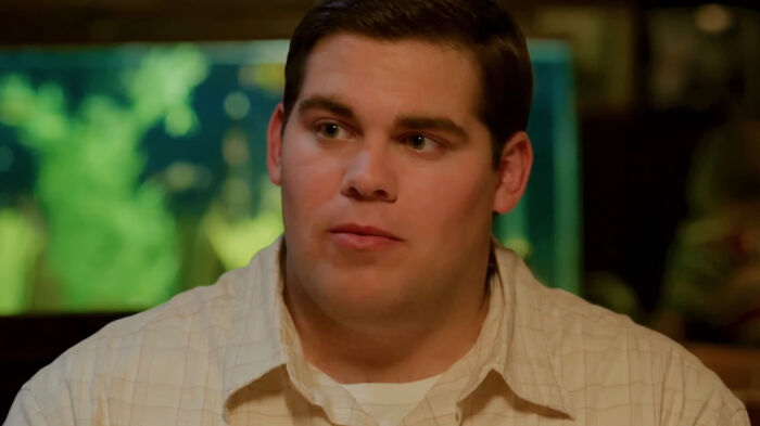 Young man in a beige shirt in a scene from a movie based on true stories that feel impossible to believe.