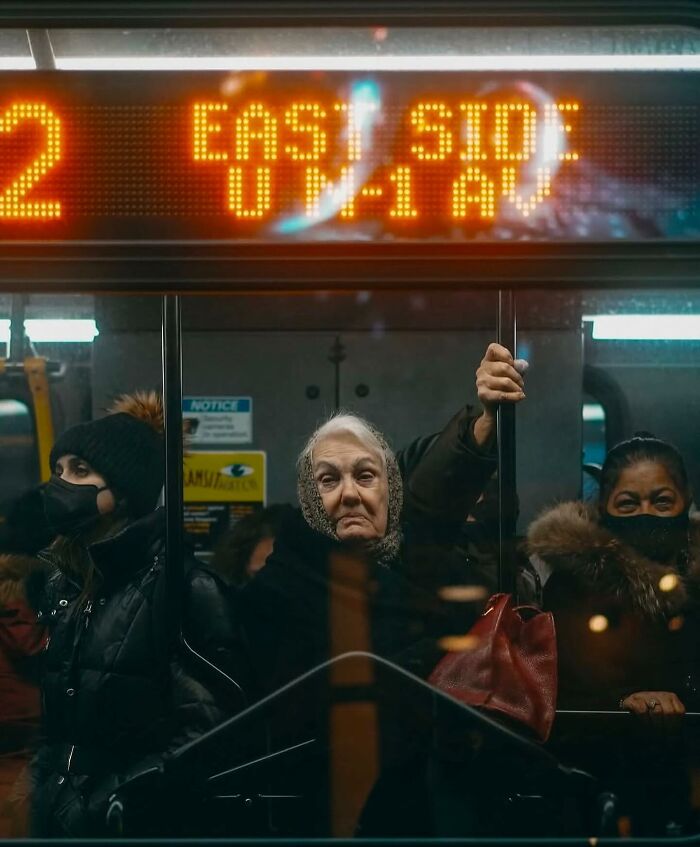 Elderly woman on a crowded subway, capturing the beauty and wisdom of old age in a powerful street photo.