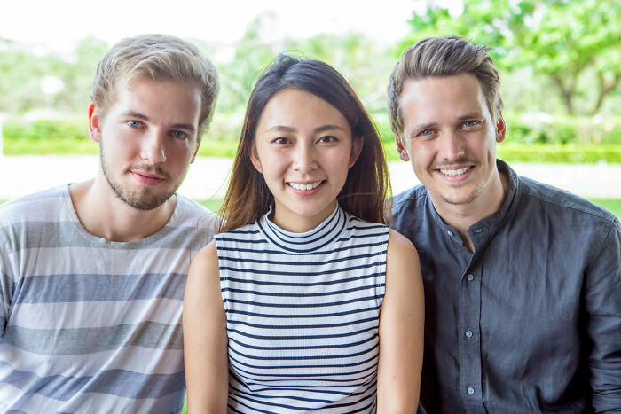 Three friends smiling together outdoors, capturing a moment relevant to painful table for two waiter experiences.