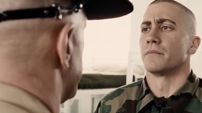 A soldier in camouflage uniform facing a commanding officer in a military setting, from movies based on true stories.