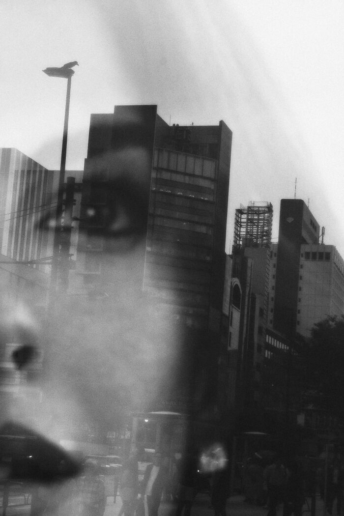 Blurred black and white street photography capturing urban life and unexpected moments in a bustling city scene.