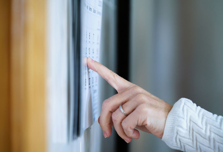 Person pointing to a calendar on a wall, symbolizing no tax on overtime and potential 2025 tax return boost.