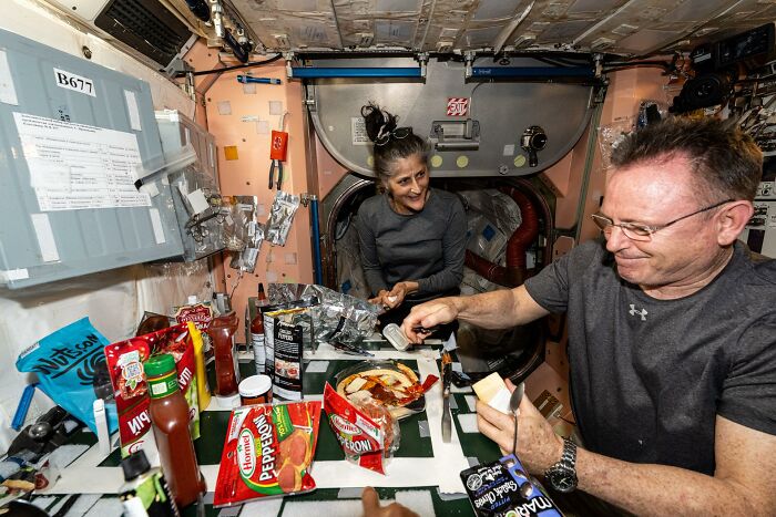 Astronauts sharing a meal inside a space station showcasing the beauty and mystery of space exploration.