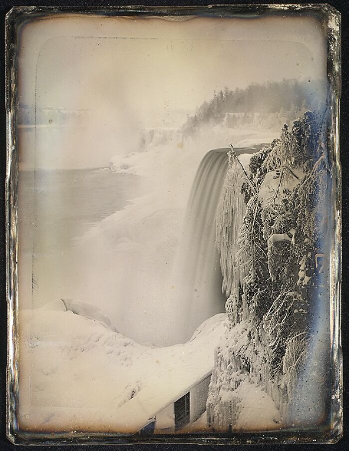 Early photography showing a winter scene with a frozen waterfall and snow-covered landscape from a historic photograph.