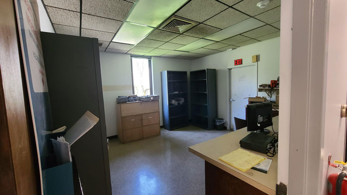 Office space with old furniture and computer being cleaned out after deceased coworker's grime buildup.