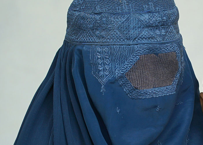 Close-up of blue embroidered fabric with detailed stitching, symbolizing moms sharing kid embarrassment moments.