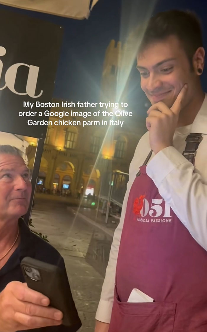 American tourist trying to order Olive Garden dish in Italy, leaving waiter looking confused and slightly disgusted outdoors at night.