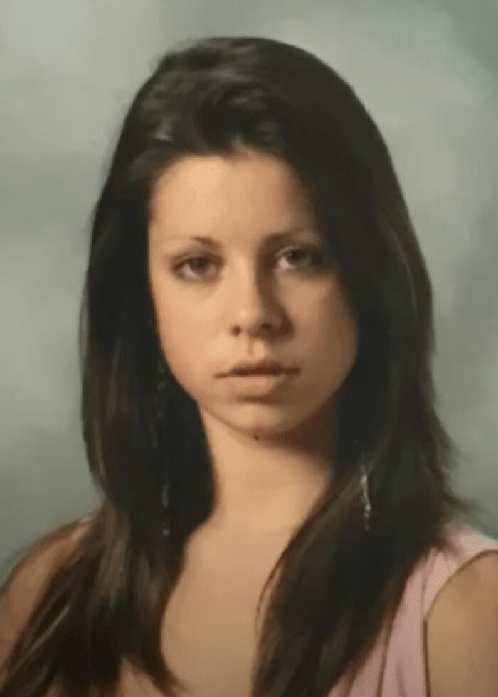 Young woman with long dark hair in a pink top shown in before photo of plastic surgery enthusiast BBL transformation.