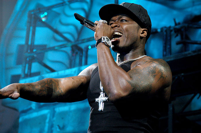 Male hard rock singer performing energetically on stage with microphone, related to hard rock cover and AI music boom.