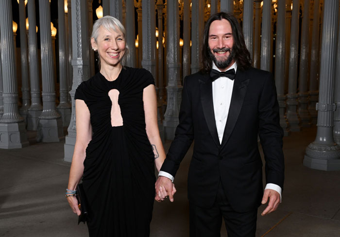 Keanu Reeves and Alexandra Grant holding hands at a formal event amid marriage rumors speculation.