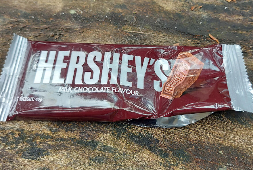 Hershey’s milk chocolate candy bar wrapper lying on wood surface, popular Halloween candy of 2025 ranking.