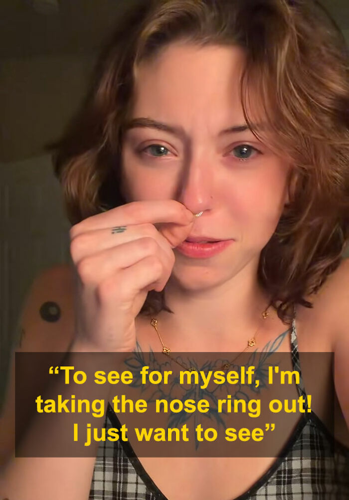 Young woman removing nose ring in close-up, going viral after men say she looks like a Democrat without it.