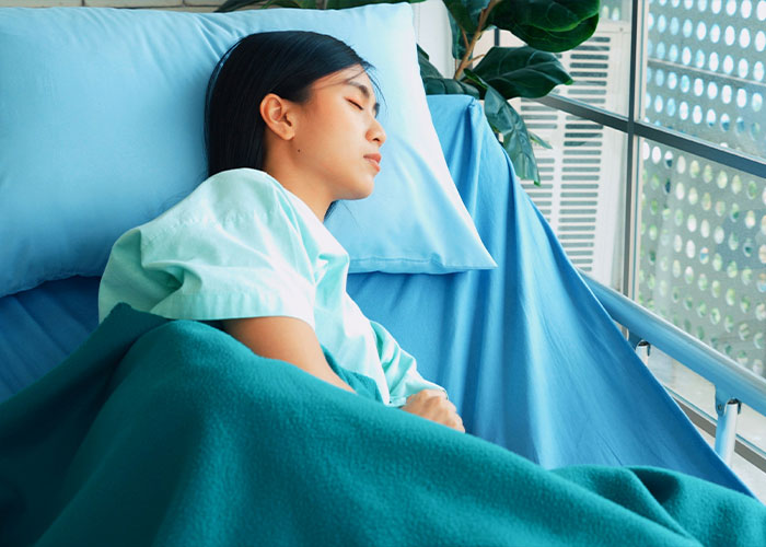 Young woman resting in a hospital bed, illustrating scientific discovery related to breathing through the bottom. Young woman resting in a hospital bed, illustrating scientific discovery related to breathing through the bottom.