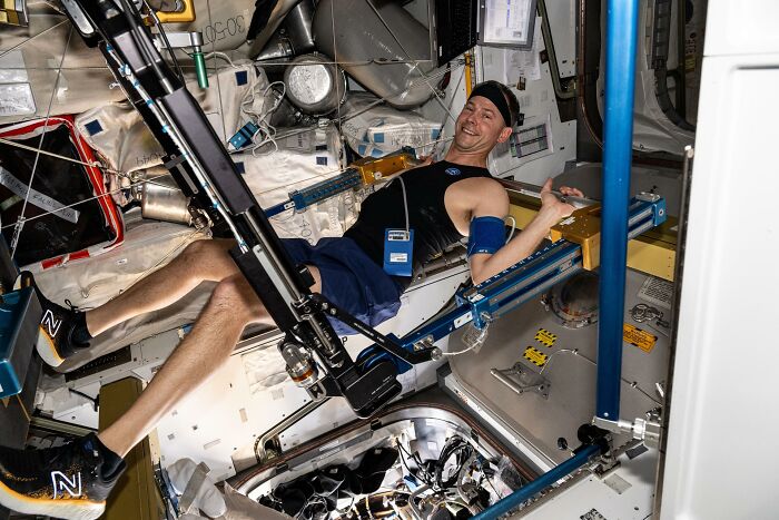 Astronaut exercising in space station module showcasing epic astronomy and the beauty and mystery of space environment.