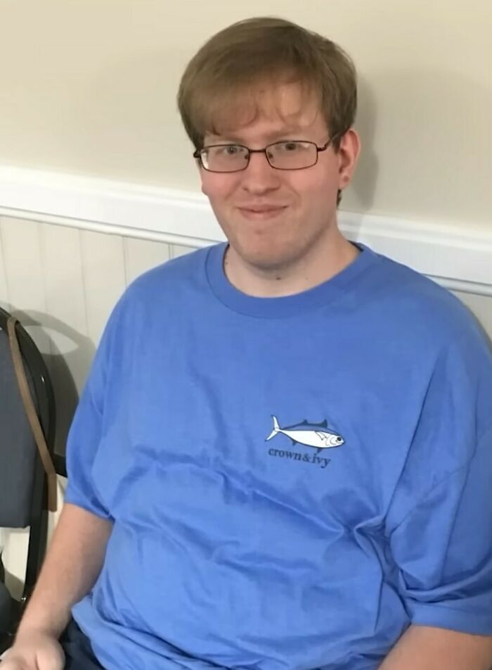 Young man with glasses wearing a blue shirt, symbolizing emotional reaction after missing brother found alive in basement case.