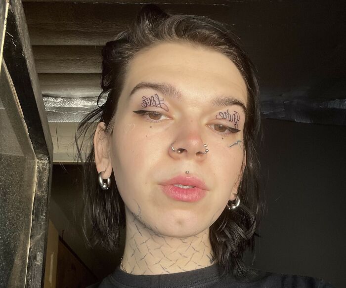 Person with face and neck tattoos and piercings, illustrating strange tattoo artists who refused to ink on people.