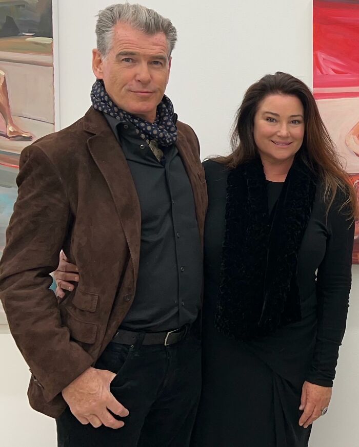 Pierce Brosnan and his wife posing together indoors, with her showing off a slimmer-than-ever frame at 62. Pierce Brosnan and his wife posing together indoors, with her showing off a slimmer-than-ever frame at 62.