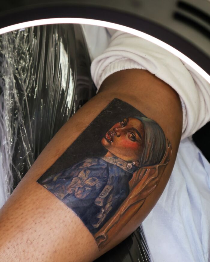 Realistic tattoo portrait on leg showcasing intricate detail by a tattoo artist known for strange and offensive tattoo refusals.