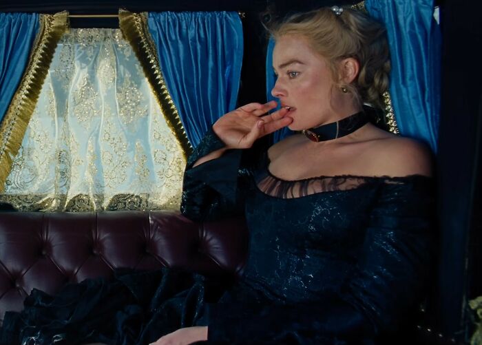 Margot Robbie in a provocative Wuthering Heights trailer scene, dressed in dark period costume inside a carriage.