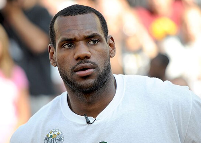 Man in a white shirt speaking into a microphone, captured in a candid moment related to kids and mortified moments.