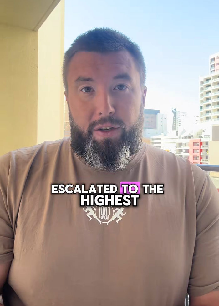 Man with a beard talks on a balcony in a city, relating a family rushed out of rental house after disturbing discovery.