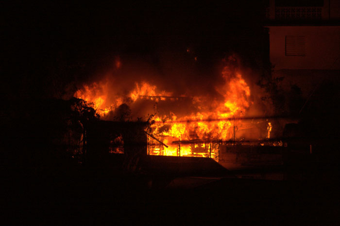 House engulfed in flames at night, illustrating one of the wildest we need to leave right now stories.