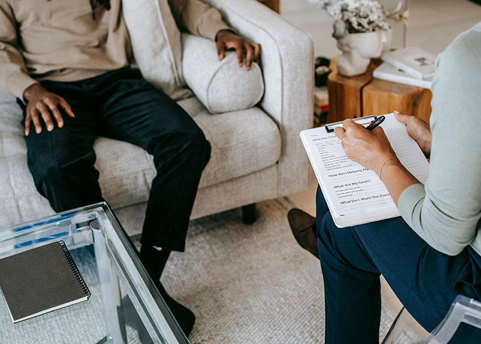 Therapist taking notes during a mental health session with patient, debunking common mental health myths.