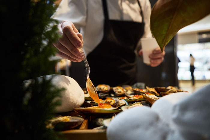 Chef in black apron preparing food, highlighting challenges bosses face with worst employees in busy kitchen setting.