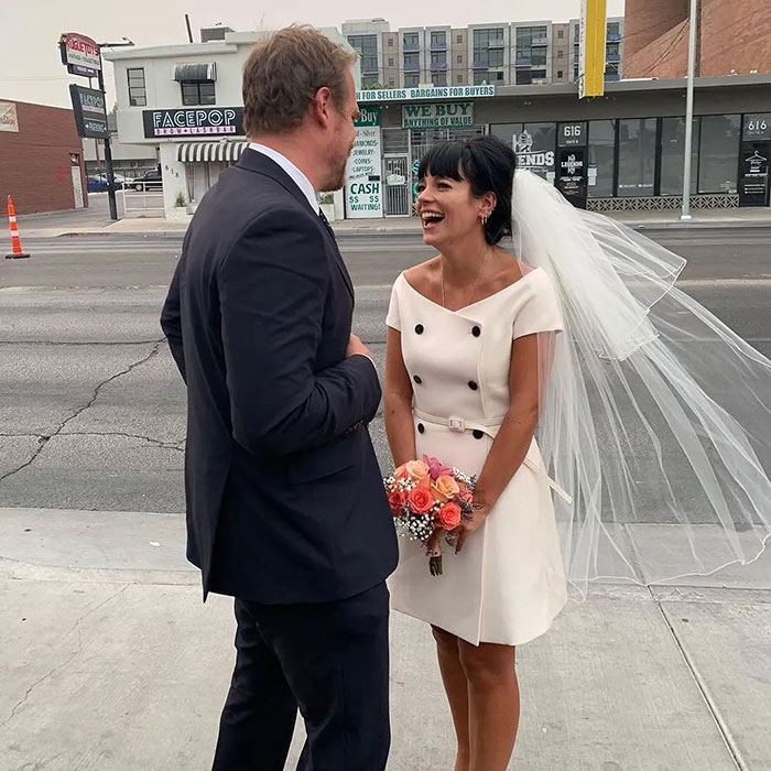 David Harbour and Lily Allen smiling on a city sidewalk, amid fans clashing online over cheating and firing debates.