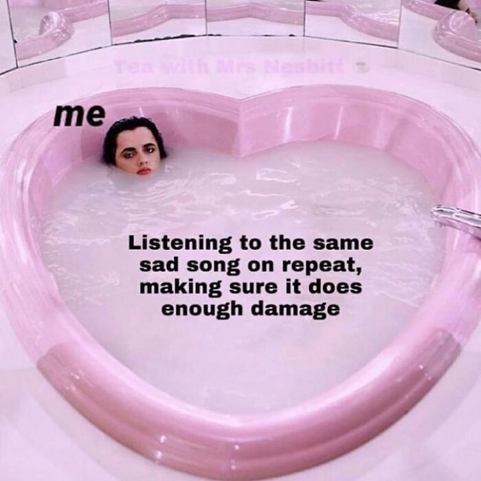Person labeled "me" submerged in a heart-shaped pink tub, caption about listening to sad songs on repeat, relatable meme for horror fans.