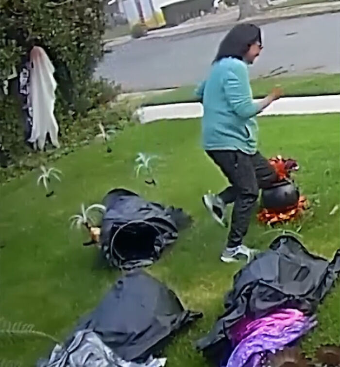 Woman attacking neighbor's Halloween witches decorations on lawn with smashed props and disrupted yard items visible.
