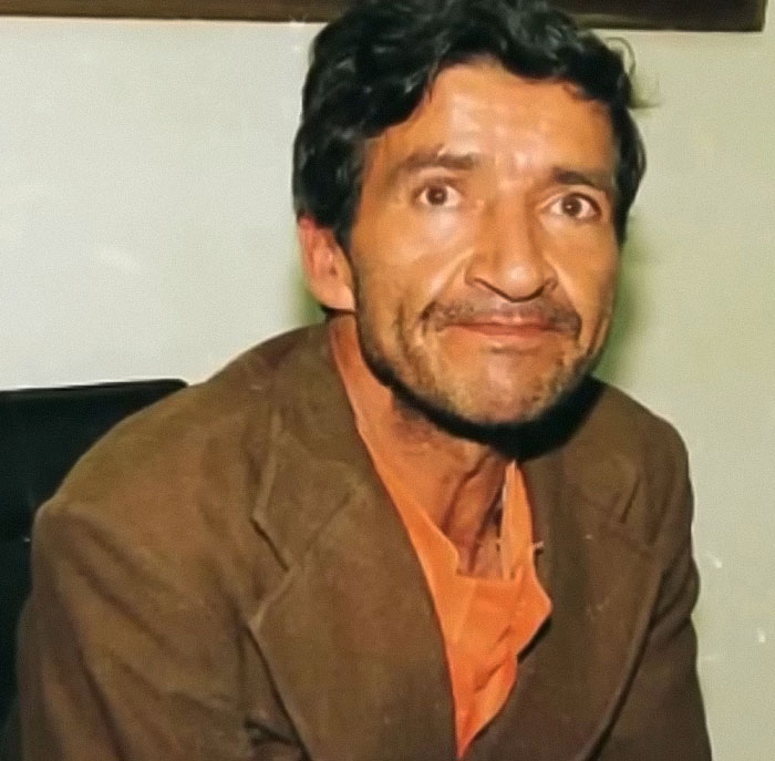 Man with dark hair and beard wearing brown jacket, related to monster who strangled over 100 young girls recently freed.