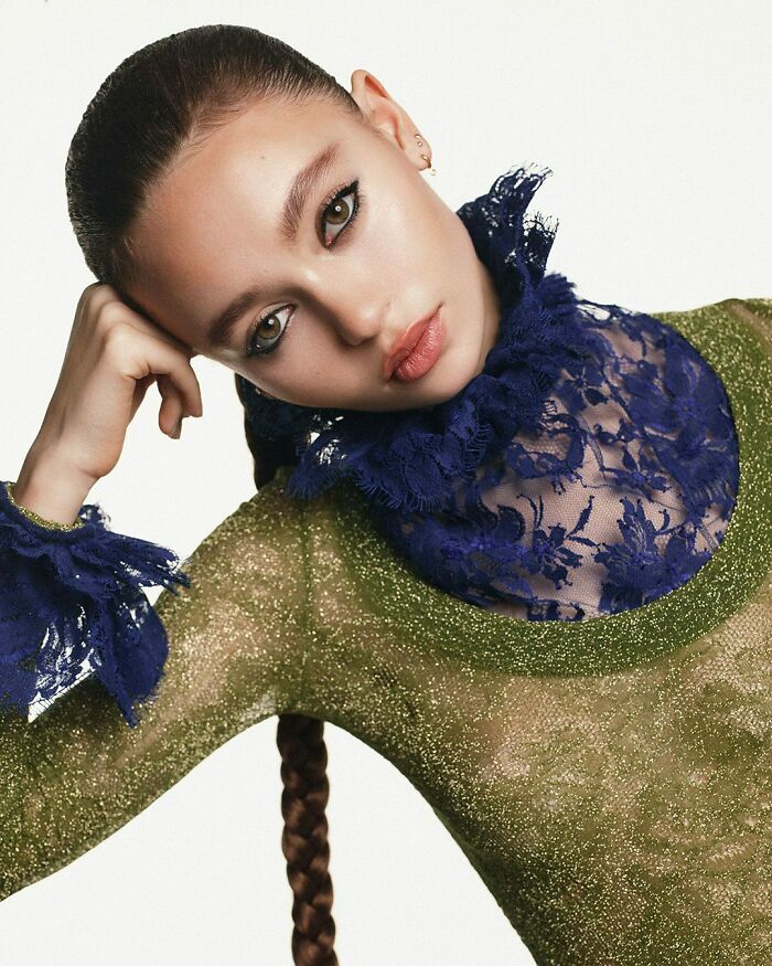 Young woman posing in a sheer green top with navy lace details, representing nepo babies defining Hollywood’s new generation.
