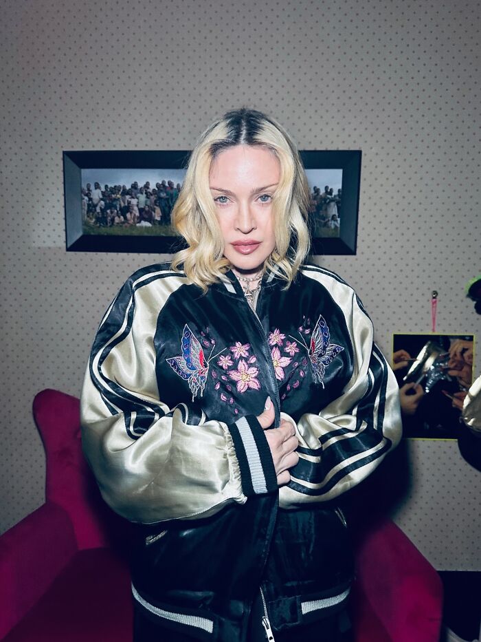 Madonna standing indoors wearing a butterfly-embroidered jacket, fans concerned about her disheveled Paris appearance.