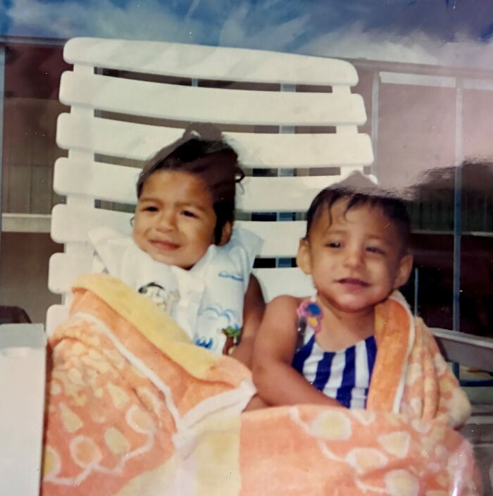 Two young sisters wrapped in towels sitting on a lounge chair, representing the miracle of their discovery after 36 years.
