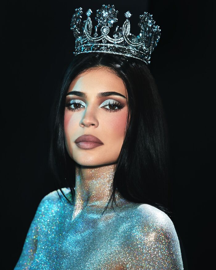 Kylie Jenner wearing a jeweled crown and glittering body makeup, linked to controversy over fake arrest video and ICE raids.