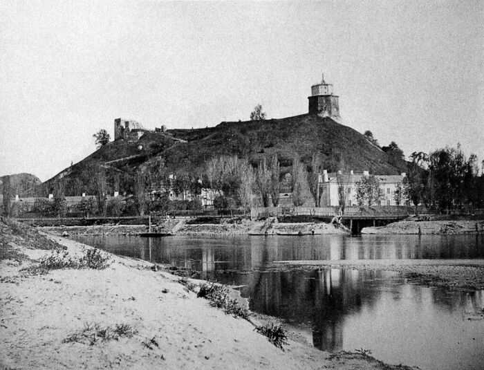 Black and white photo of a historic world capital with a hilltop fortress and river in an early time period.