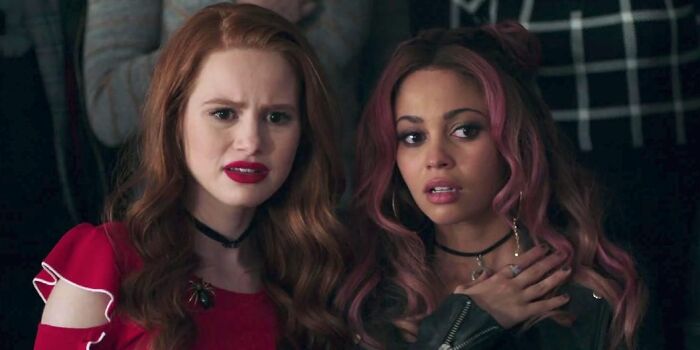 Two women with expressive faces in a movie scene illustrating unrealistic women movie tropes still annoying viewers.