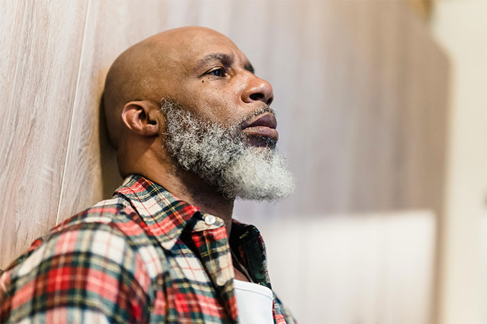 Middle-aged man with gray beard and plaid shirt looking pensive, symbolizing brutal truth after leaving wife for younger woman.