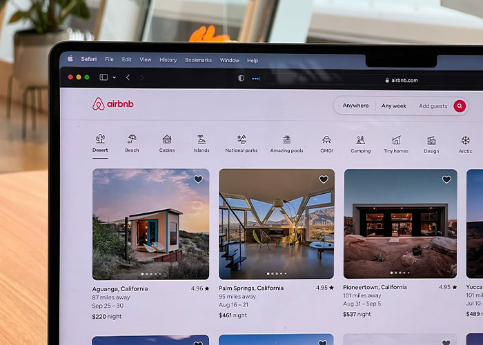 Laptop screen showing rental house listings on Airbnb, related to family rushing out after disturbing discovery.