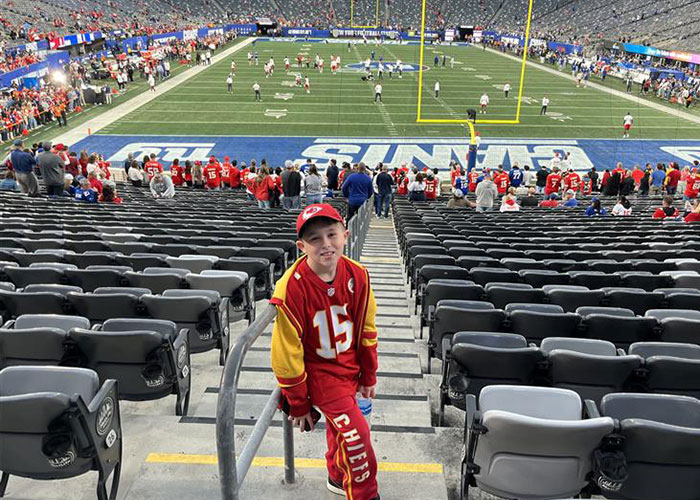 Young Kansas City Chiefs fan at stadium, related to viral Kansas City Karen headband incident involving 10-year-old boy.
