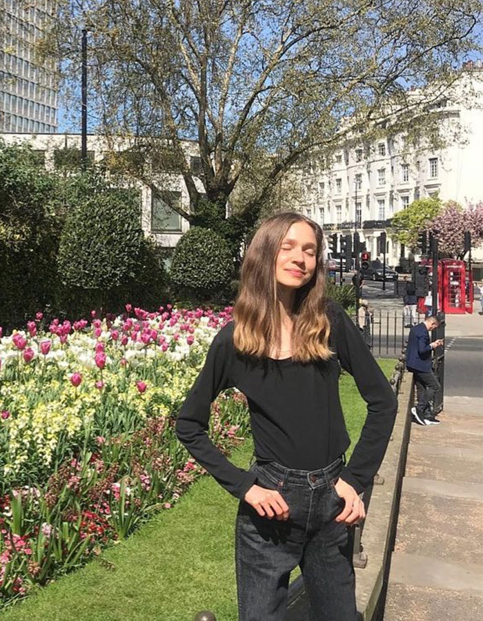 Young vegan woman posing near flower garden in bright daylight, related to raw diet lifestyle and health awareness. Young vegan woman posing near flower garden in bright daylight, related to raw diet lifestyle and health awareness.